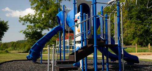 Playground equipment set on park grounds — shows family-friendly onsite recreation (homepage background/slide).