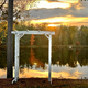 Sunset view across the pond with a decorative arch in foreground — clear scenic shot of the property’s pond and shoreline.