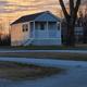 Small standalone cabin on a gravel loop — demonstrates cabin lodging option on the property and its relationship to nearby RV pads and grounds.