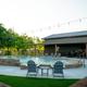 Clear image of the resort’s outdoor swimming pool with seating, surrounding deck and clubhouse in background — matches the homepage/amenities pool image on the property website (page: root /amenities and homepage).