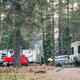 RV campsite scene showing multiple full‑hookup RVs, picnic setup and trees — clearly depicts the resort’s RV camping area and site character (from Accommodations page).