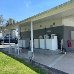 Outdoor laundry facility with multiple washers/dryers and covered seating — useful facility photo from the park Gallery (IMG_0082).