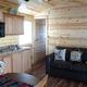 Interior view of a cabin (Cedar Lodge) showing kitchen and living area — matches gallery page listing cabin accommodation on the campground site.