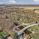 Aerial overview showing campground grounds, trees, road bridge, and surrounding fields — useful for overall layout (homepage/Attractions context matches property).