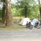 Tent campsite area with picnic table, trees and parked motorcycles — useful view of tent camping spaces and wooded surroundings shown on the property’s gallery.