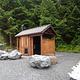 outhouse with large boulders and trees