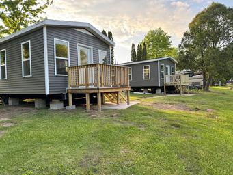 Two bunkhouses/cabins on grassy area with decks — useful to showcase on-site cabin/bunkhouse accommodations (from bunkhouses page).