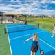 Daytime image of on-site pickleball courts with resort grounds and RVs visible beyond — demonstrates recreational facilities located on the campground property (matches ‘amenities’ page content).