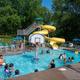 Main swimming pool with a large water slide and lounge chairs — shows the pool amenity and guest use (homepage image of pool area).