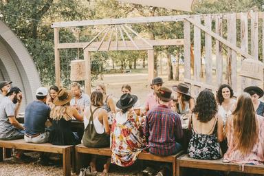 Outdoor dining workshop table set beneath oak trees at Serana