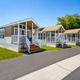 Exterior shot of three cabin units on paved lot with porches and landscaping — shows the cabin accommodation style on site (gallery page source).