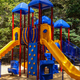 Playground equipment photograph (bright slides and climbing structures) labeled 'Playgrounds' on the site's home page — useful for family/campsite gallery.