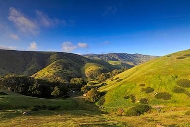 View of canyon nestled in low rolling, grass covered hills.