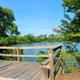 Wooden viewing dock/boardwalk overlooking the pond with clear water and shoreline — from the 'Amenities' page and good for highlighting lakeside scenery.