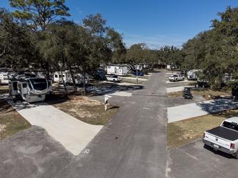 Ground-level aerial/street-facing view showing concrete RV pads, hookups and road—good for conveying typical site appearance (from gallery).
