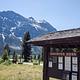 View of campground self-service kiosk with trees and a mountain in the background.