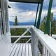Double Arrow Lookout Tower- Exterior deck facing North to Seeley Lake water body and Richmond Ridge Mountains. Cotton Candy colored clouds during sunset.
