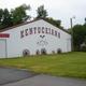 Shows the exterior of a property building with large “KENTUCKIANA” lettering and decorative wagon wheels — useful for identifying on-site facility; sourced from the home page of the campground.