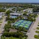 High-altitude aerial view showing the resort layout: rows of RV sites, central pool and courts, water features and surrounding neighborhood — matches the homepage/gallery DJI image (site root background).
