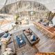 Wide interior view of a large dome living area and kitchen/bar, demonstrating the communal indoor space and layout used in the glamping units.