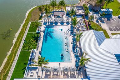 Close aerial/angled view focused on the main pool and club area with adjacent landscaping — highlights resort amenities and pool design (page context: resort amenities imagery).