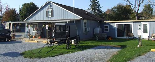 Wide exterior shot of the campground office/entrance area with an antique buggy on the lawn — useful overview of the park facilities and entrance; comes from the site’s Our Park feature image.