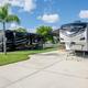 Concrete RV pads with two parked units and palm trees — typical onsite RV pitch view from the gallery showing site setup and spacing.