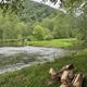 Riverside scene with flowing water, grassy banks and nearby hills — attractive on-site natural scenery consistent with property imagery.