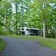 Bandy Creek Campground road with fifth-wheel horse trailer in a campsite in Loop B. Grass and green trees.