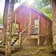 Rustic wooden cabin surrounded by trees at Old Forge Camping Resort.