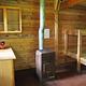 Frosty Bay Cabin Interior of wood cabin with bunk and stove