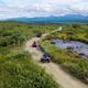 Riders enjoying a scenic ATV tour in Alaska with stunning mountain views