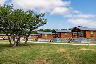 Wide exterior shot of multiple cabins with grounds in front, useful to show cabin cluster and site landscaping (image appears on the About Us / cabins pages).