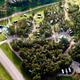 High-angle aerial view showing the campground layout with RVs, pull-through sites, roads and wooded areas — clear property overview matching the site’s gallery (filename OVERHEAD.jpeg).