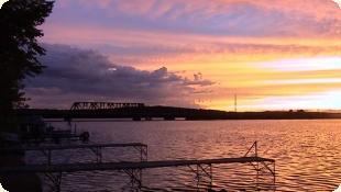 Sunset over lake with docks in foreground — from the site's photo galleries, represents scenic waterfront views available at the campground.