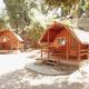 Clear daytime photo of on-site log cabins with porches and surrounding oaks — matches campground’s accommodations (hero image on the property page).