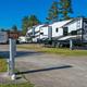 Close view of an individual concrete RV pad with utility pedestal (site marker 105) and multiple RVs in the background — good detail of site size and hookups (from rates/gallery pages).