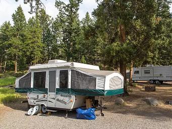 A popup camper in the woods at Tower Fall Campground