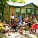 Group gathered outside a cabin on a paved patio in front of a cabin structure — good depiction of the campground’s cabin accommodations and outdoor gathering space (from the campground gallery).