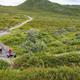 Outdoor enthusiasts on an Alaskan ATV tour, pausing in a scenic field