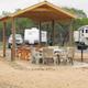 Covered picnic/BBQ pavilion with tables and grills and RVs in the background — useful facility shot of on-site picnic and campsite area from the park photography.