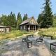 Swan Guard Station exterior. Fire ring and benches in the foreground. Cabin, vault toilet, and firewood shed in the background.