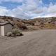 A view of the dirt parking area and vault toilet as you enter the group site