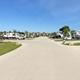 Clear, wide photo of the park entrance/main drive showing multiple RV pads, landscaping, and the overall layout; comes from the property's Gallery page (strong evidence it's on-site).