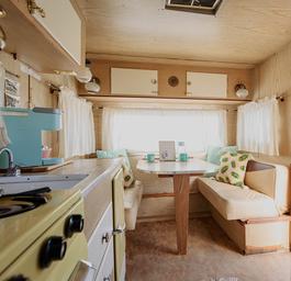 Interior of a restored vintage trailer, showing the kitchenette and seating—demonstrates accommodation interior and amenities (source page: homepage).