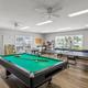 Indoor game room with pool table, ping-pong and large windows overlooking the grounds — demonstrates on-site recreation facilities in the gallery.