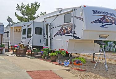 Photograph of an RV parked at a paved site with outdoor furnishings and landscaping — useful to show typical RV pitch style at this resort (from the resort gallery).