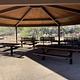 Under the ramada, with a view of picnic tables and benches