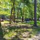 Shaded tent camping area showing tent, picnic table, vehicles and RV sites — useful campsite overview. File is from the Home page (TENT‑SITE image) indicating it depicts the campground.