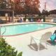Outdoor swimming pool with surrounding chairs and RVs visible beyond — clearly shows the park’s pool amenity (page: https://rainbowsend.escapeesrvparks.com/amenities/).